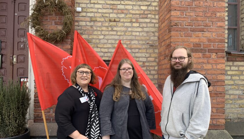 Framför röda fanor står Ulrica Högbergh, Carola Forslund och Olle Jonsson